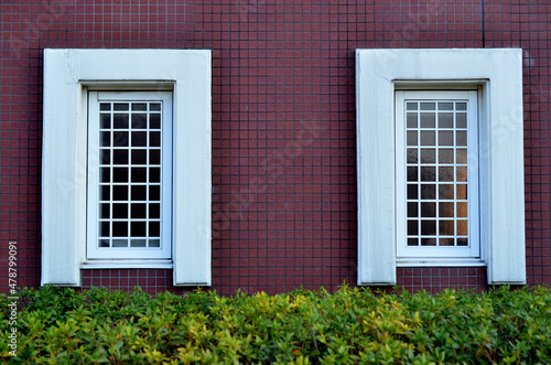 赤いタイルの壁の白枠の格子窓