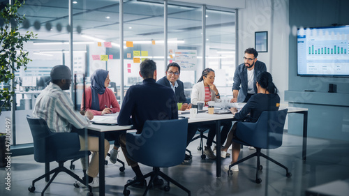 Multi-Ethnic Office Conference Room Meeting: Diverse Team of Young Entrepreneurs, Specialists Talk, Use TV for infographics. Smiling Businesspeople Discuss Investment Strategy in e-commerce Startup
