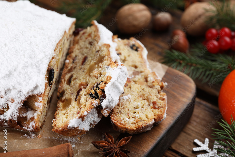 Traditional Christmas Stollen with icing sugar on wooden table, closeup Traditional Christmas Stollen with icing sugar on wooden table, closeup