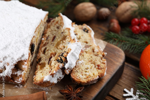 Traditional Christmas Stollen with icing sugar on wooden table, closeup