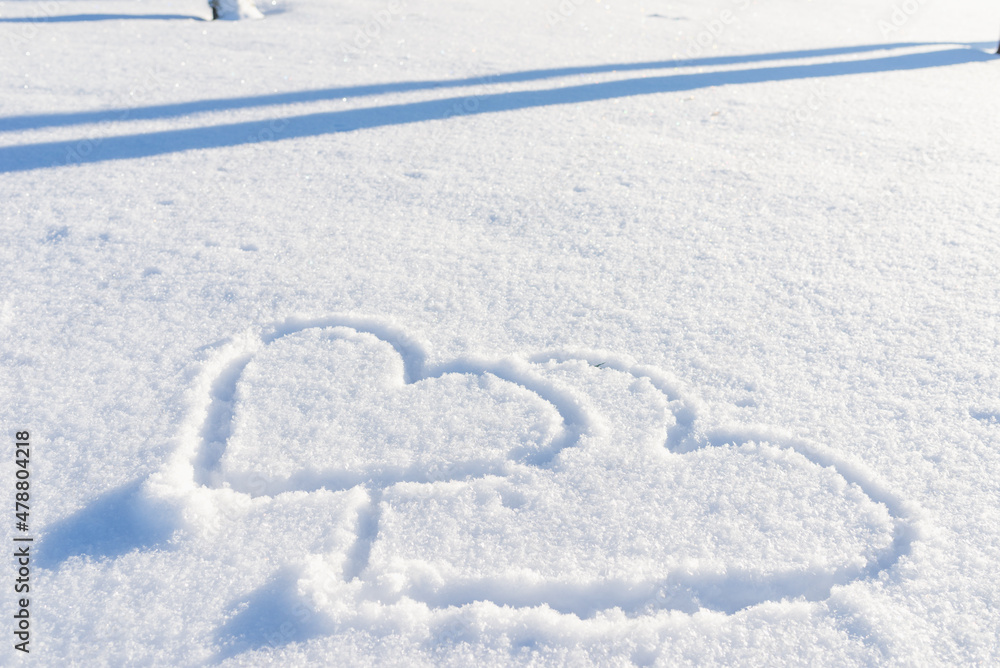 Two drawn heart shape in the fresh snow.