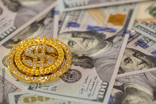 golden dollar sign with gemstones on 100 dollar banknote background