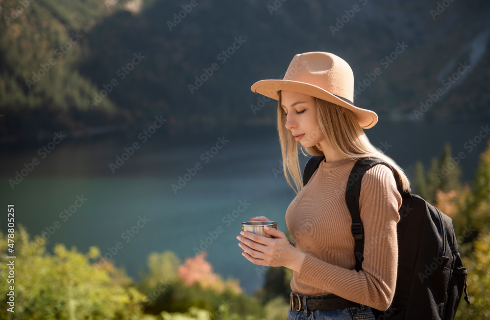 A tourist girl is resting after a hard climb up the mountain.