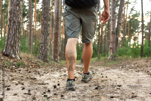 Caucasian man muscular legs trekking along ground path
