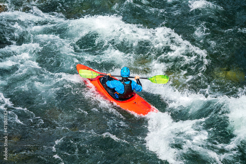 River kayaker in red kayak are paddling whitewatered river. Extreme sports and adrenaline concept. Removed logos. © Jon Anders Wiken