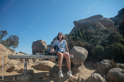 A Beautiful Mature Woman Sitting on the Becnh at the Bishop Peak Summit after a Long Hiking Adventure photo