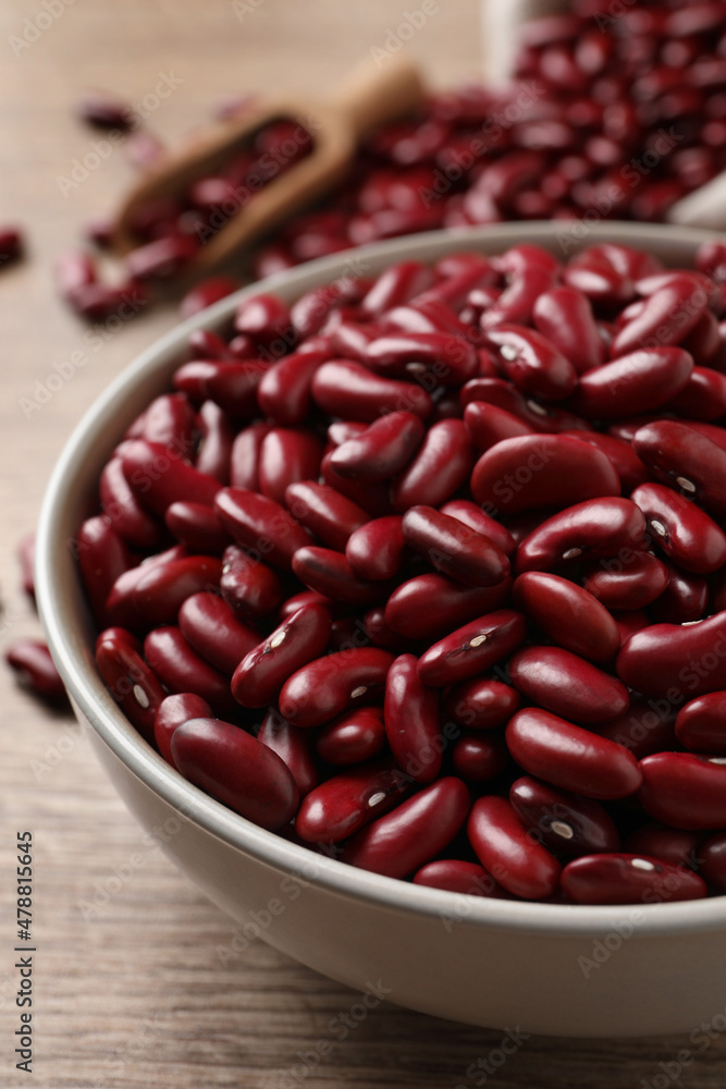 Raw red kidney beans in bowl on wooden table, closeup Raw red kidney beans in bowl on wooden table, closeup