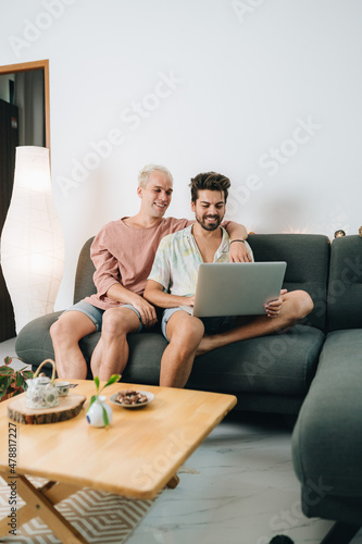 Wallpaper Mural Gay couple sitting on sofa with laptop Torontodigital.ca