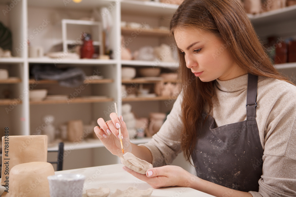 Beautiful woman making pottery from clay at art studio, close up Beautiful woman making pottery from clay at art studio, close up