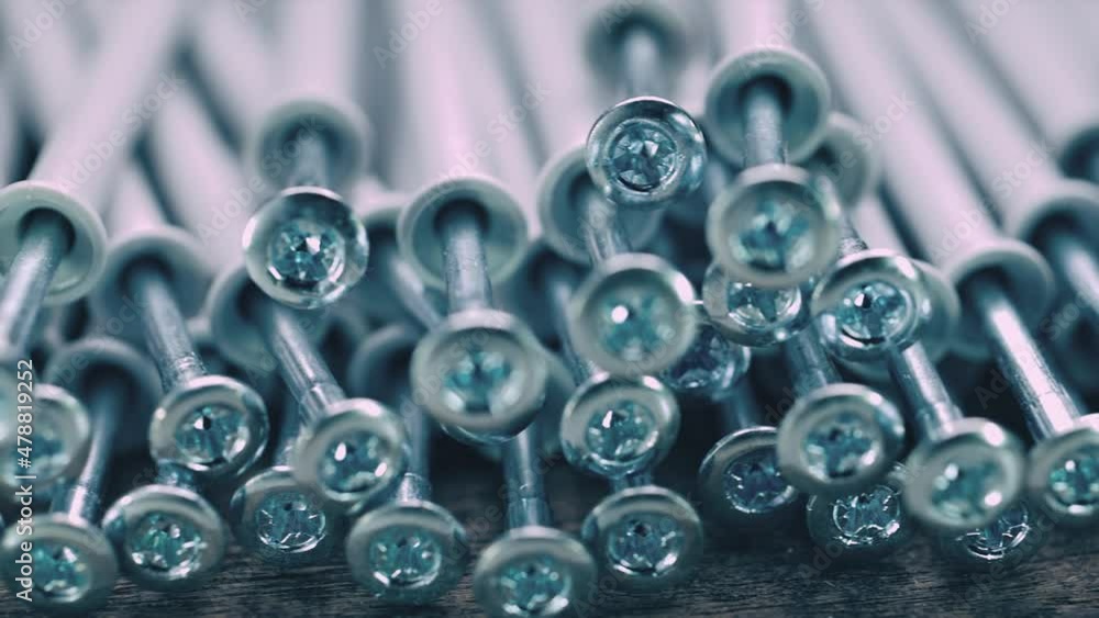 Selective focus. Close up shooting of parts of carpentry screws with cross head. Yellow screws on the table. Industry background Selective focus. Close up shooting of parts of carpentry screws with cross head. Yellow screws on the table. Industry background