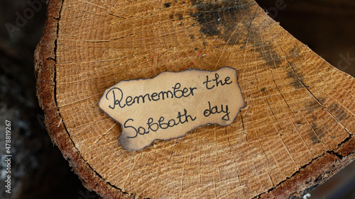 Bild auf Leinwand Remember the Sabbath Day text quote handwritten on old paper on an oak wooden log