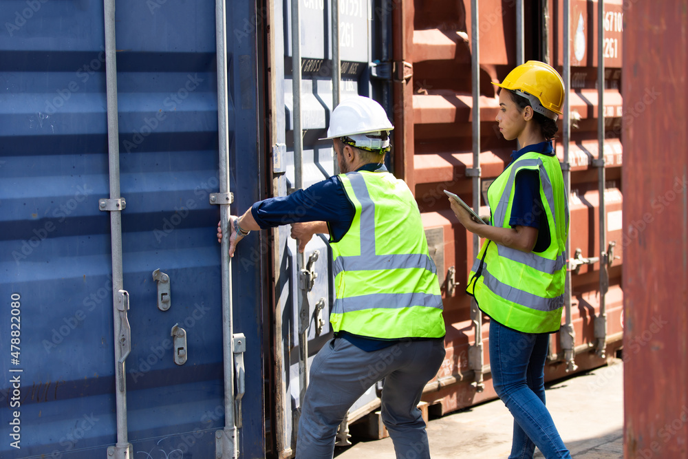 Hispanic Man worker and woman Supervisor dock cargo checking and control loading Containers box at container yard port of import and export goods. Unity and teamwork concept Hispanic Man worker and woman Supervisor dock cargo checking and control loading Containers box at container yard port of import and export goods. Unity and teamwork concept