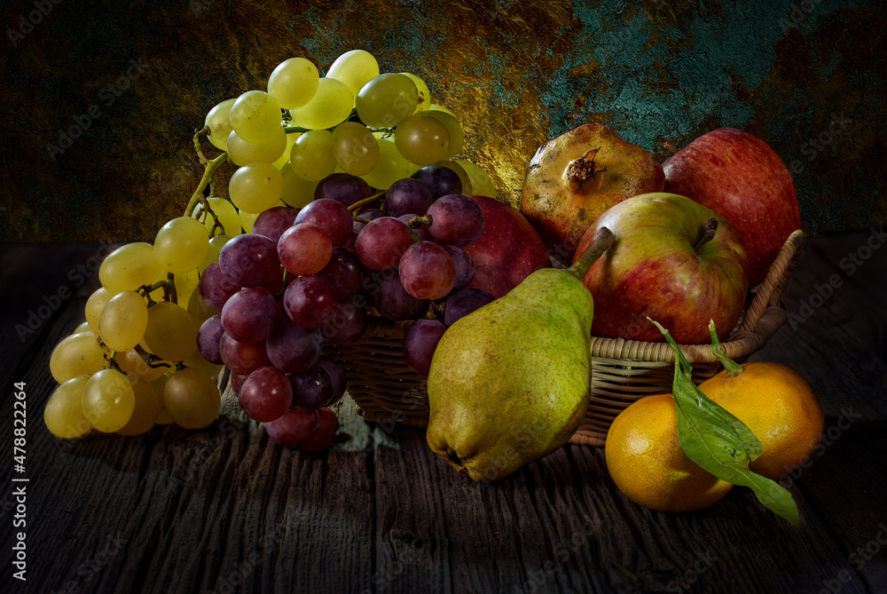 Still life fruits in a basket  on wooden table,pear, apple, pomegranate, mandarin. 