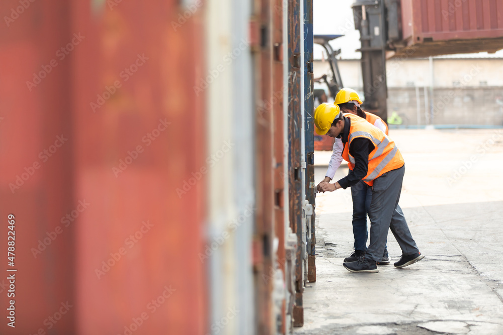 Man worker and woman Supervisor dock cargo checking and control loading Containers box at container yard port of import and export goods. Unity and teamwork concept Man worker and woman Supervisor dock cargo checking and control loading Containers box at container yard port of import and export goods. Unity and teamwork concept