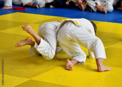 Two Girls judoka in kimono compete on the tatami 