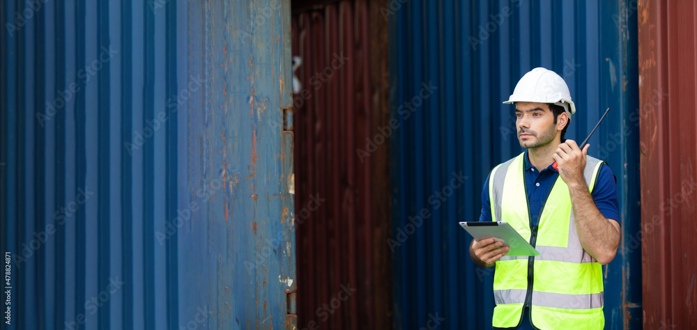 foreman manager working through a radio communication with the workers in the container yard at port of import and export goods. foreman manager working through a radio communication with the workers in the container yard at port of import and export goods.