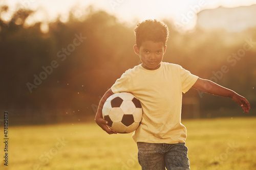 Young soccer player. African american kid have fun in the field at summer daytime © standret