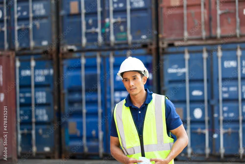 professional engineer man wearing protection face mask during coronavirus and flu outbreak and wearing safety hardhat helmet at container yard or cargo warehouse professional engineer man wearing protection face mask during coronavirus and flu outbreak and wearing safety hardhat helmet at container yard or cargo warehouse