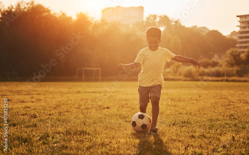 Plays soccer. African american kid have fun in the field at summer daytime #478825250