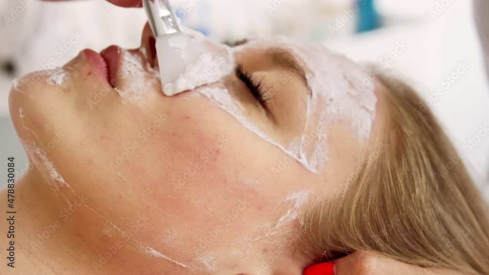 Beautician cosmetologist cleans removes face peeling beauty mask. professional cosmetic procedure in a beauty clinic salon for client. Skincare and cosmetology spa concept. Beautician cosmetologist cleans removes face peeling beauty mask. professional cosmetic procedure in a beauty clinic salon for client. Skincare and cosmetology spa concept.