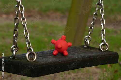 Obraz na płótnie Coronavirus spread among children - rubber toy looking like covid19 cell on a swing at the playground at the kindergarten. w salonie