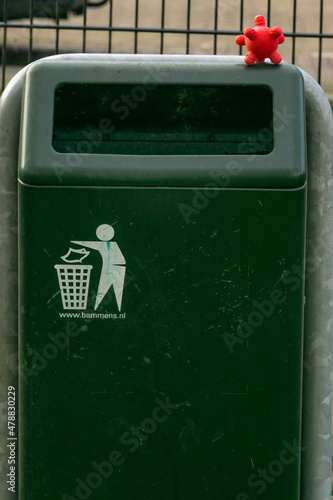 Obraz na płótnie Coronavirus covid-19 cell toy on a rubbish bin on the street. Infection danger caused by infrastructure of public space in the city. w salonie