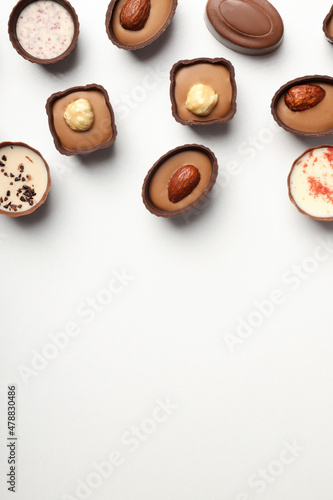 Flat lay composition with chocolate candies on white background