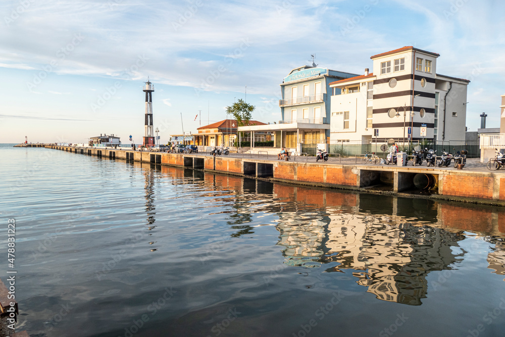 The canal that divides Cattolica from Gabicce with the buildings that are reflected in the water at sunset