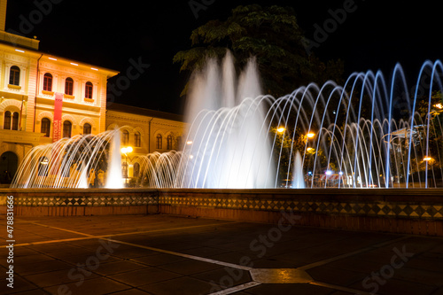 Illuminated and colored fountain with the Cattolica town hall in the background