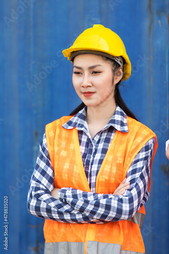 Portrait of Women worker control loading Containers box from Cargo at container yard. Import and Export concept. Marine, carrier and logistic insurance