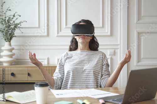 Fototapeta Peaceful woman employee meditating in glasses of virtual reality, sitting in zen