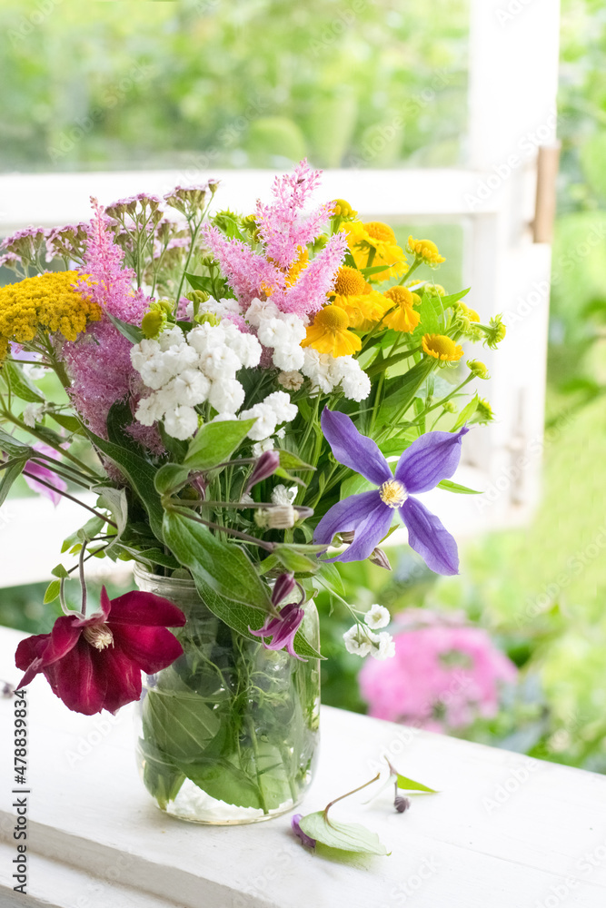 Fototapeta premium Bouquet of garden flowers on opened window