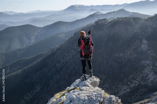 chica en la montaña con una mochila y mar de nubes de fondo