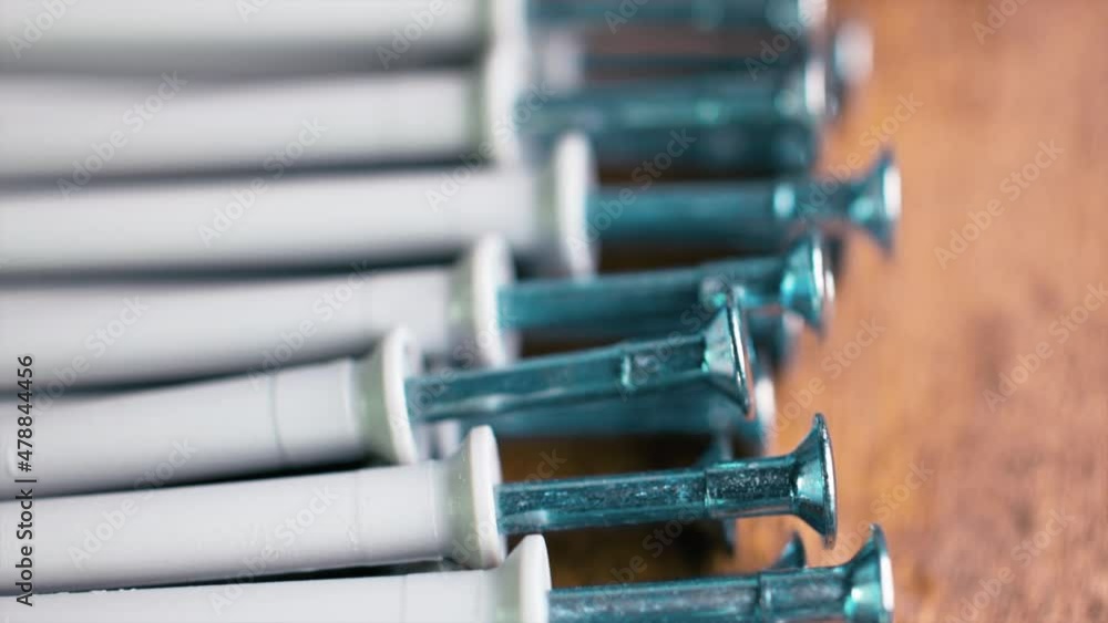 Selective focus. Close up shooting of parts of carpentry screws with cross head. Yellow screws on the table. Industry background. Selective focus. Close up shooting of parts of carpentry screws with cross head. Yellow screws on the table. Industry background.