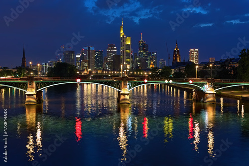 Frankfurt am Main, Germany. View from a bridge across the Main to skyscrapers of financial district in twilight. Tower of Frankfurt Cathedral is visible to the right of the skyscrapers. © Mikhail Markovskiy