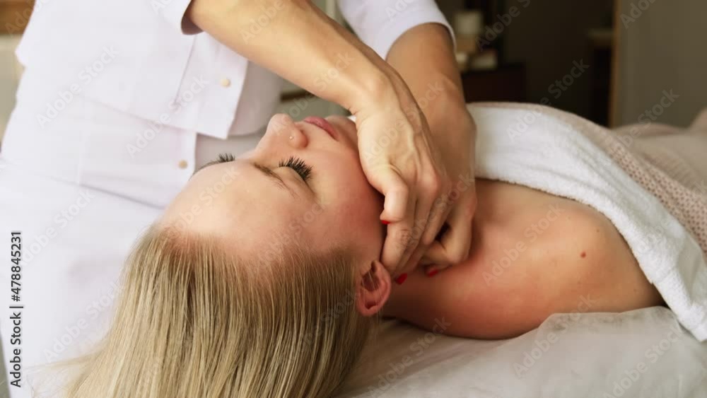 Beautician cosmetologist makes lifting face massage, pinch and roll technique, professional cosmetic procedure in a beauty clinic salon for client. Skin care and cosmetology spa concept. Beautician cosmetologist makes lifting face massage, pinch and roll technique, professional cosmetic procedure in a beauty clinic salon for client. Skin care and cosmetology spa concept.