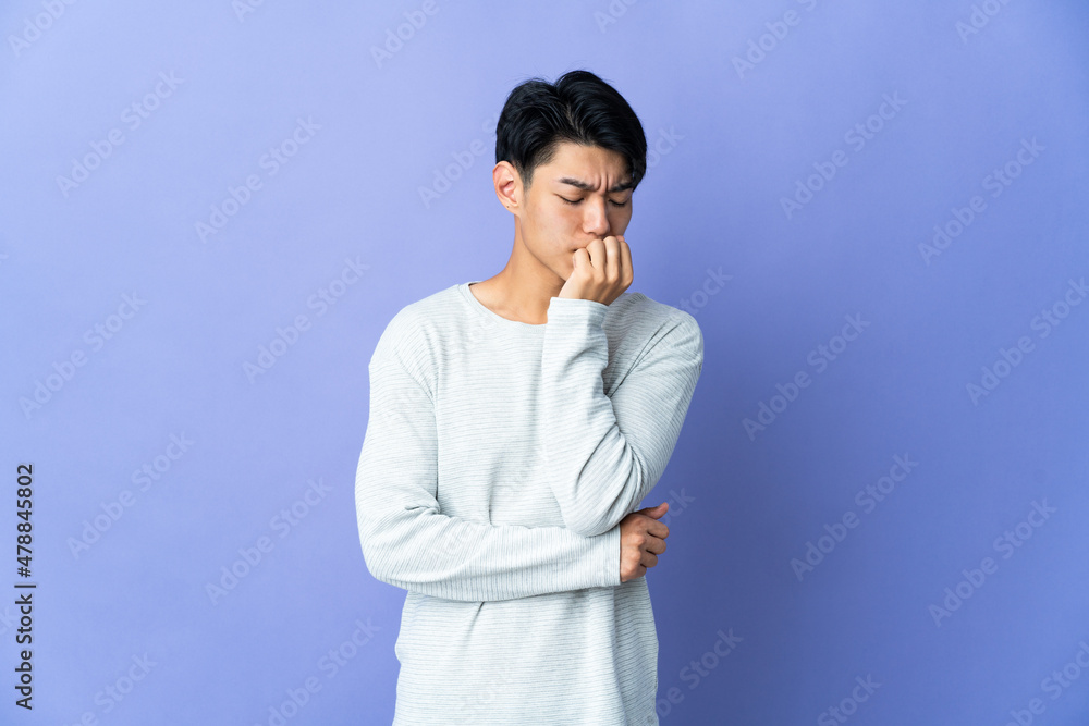 Young Chinese man isolated on purple background having doubts Young Chinese man isolated on purple background having doubts