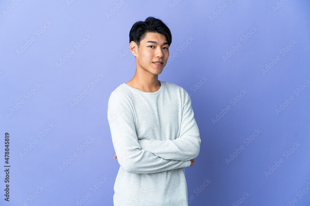 Young Chinese man isolated on purple background with arms crossed and looking forward Young Chinese man isolated on purple background with arms crossed and looking forward