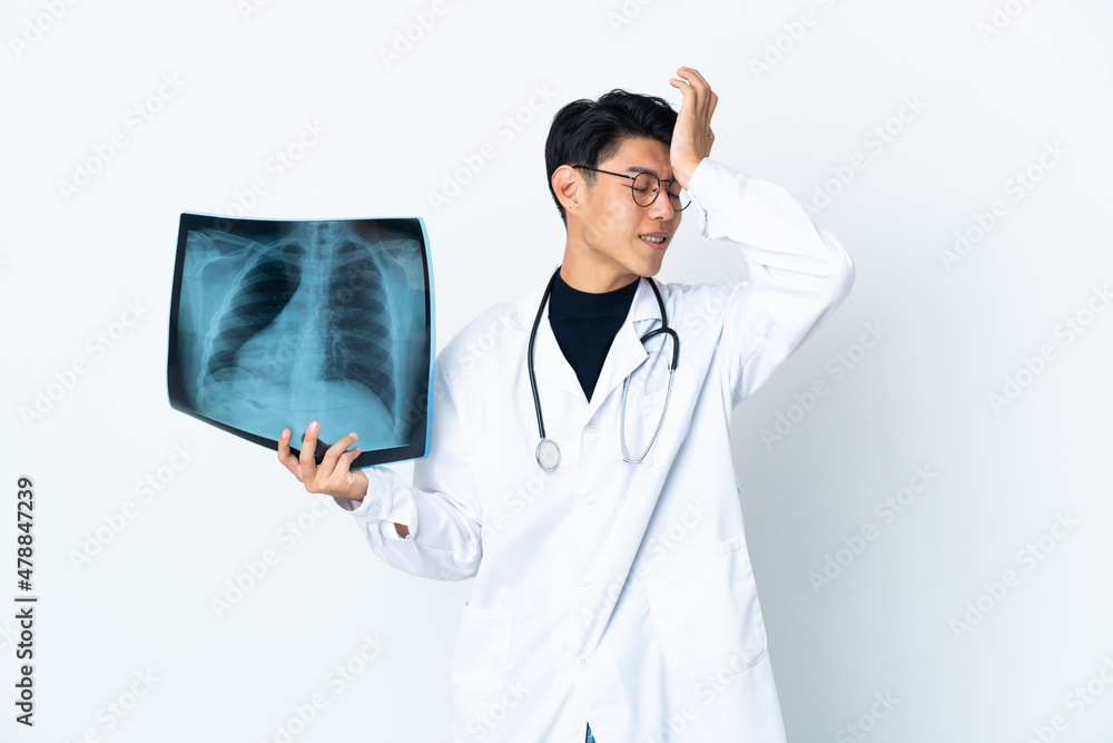 Young Chinese doctor man holding radiography isolated on white background has realized something and intending the solution Young Chinese doctor man holding radiography isolated on white background has realized something and intending the solution