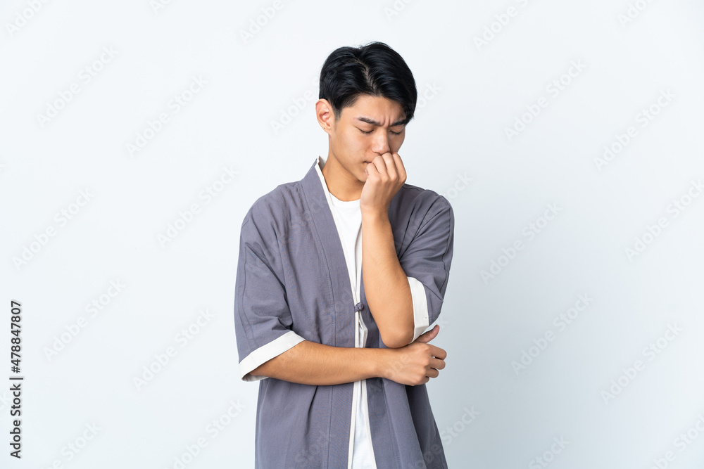 Young Chinese man isolated on white background having doubts Young Chinese man isolated on white background having doubts
