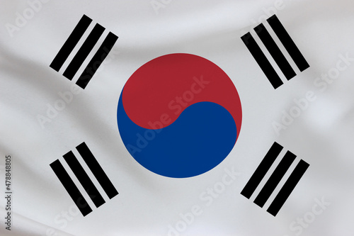 South Korea flag on waving silk background. Fabric texture.