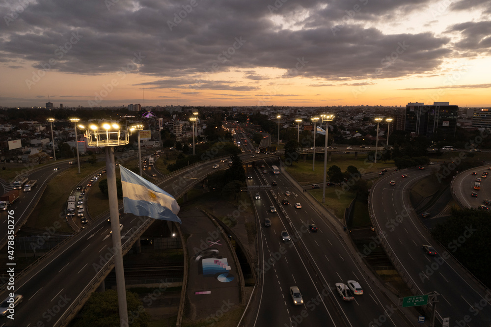 Toma aerea de autopista al atardecer con bander argentina - obrazy, fototapety, plakaty 