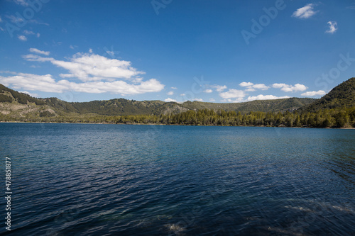 Scenic view of lake and mountains against clear blue sky, horizontal photo