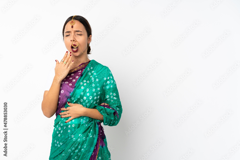 Young indian woman isolated on white background yawning and covering wide open mouth with hand Young indian woman isolated on white background yawning and covering wide open mouth with hand