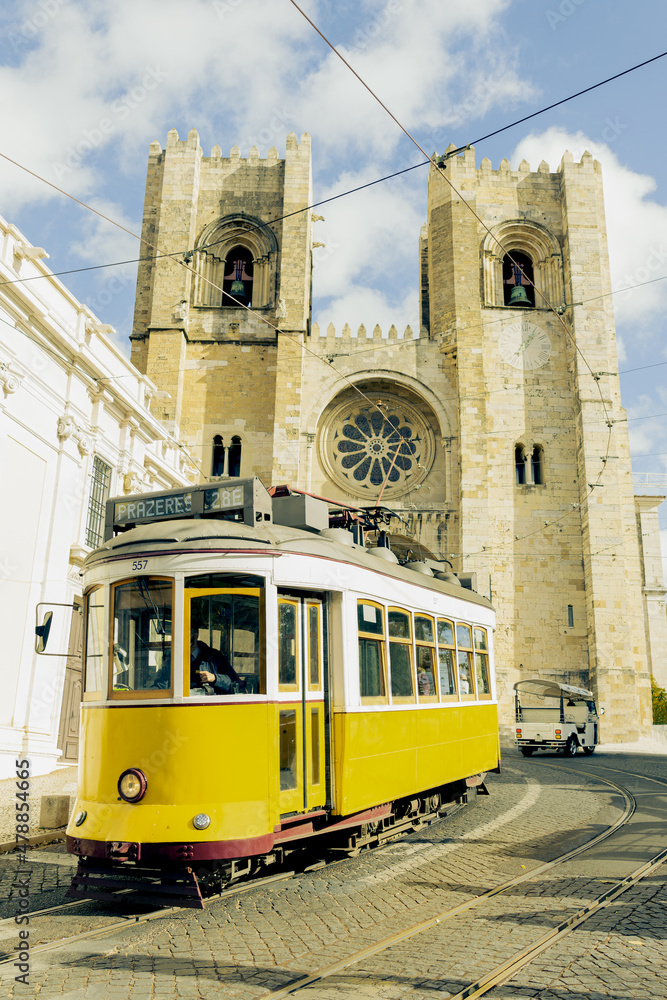 Yellow tram next to the cathedral of Lisbon, Portugal