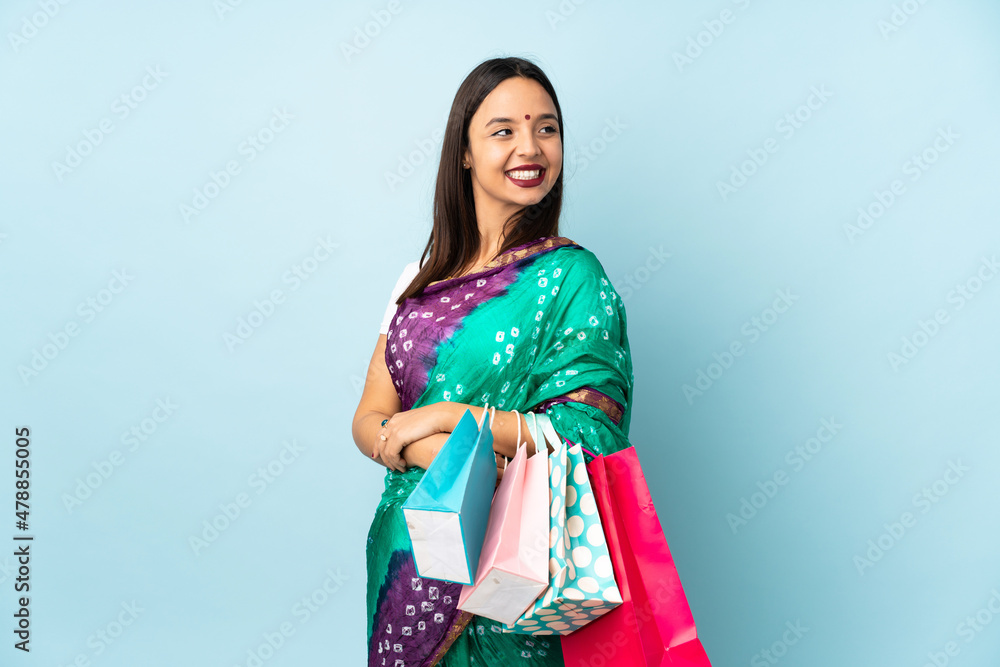Young Indian woman with shopping bags with arms crossed and happy Young Indian woman with shopping bags with arms crossed and happy