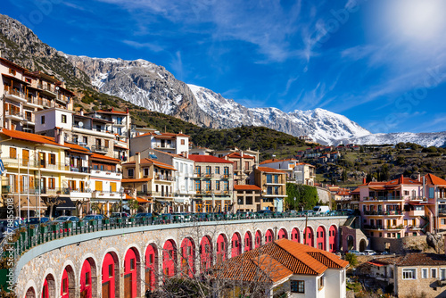 Fototapeta Naklejka Na Ścianę i Meble -  Panoramic view of the town Arachova, Greece, next to Parnassus mountain during a sunny winter day with snow capped mountains in the background