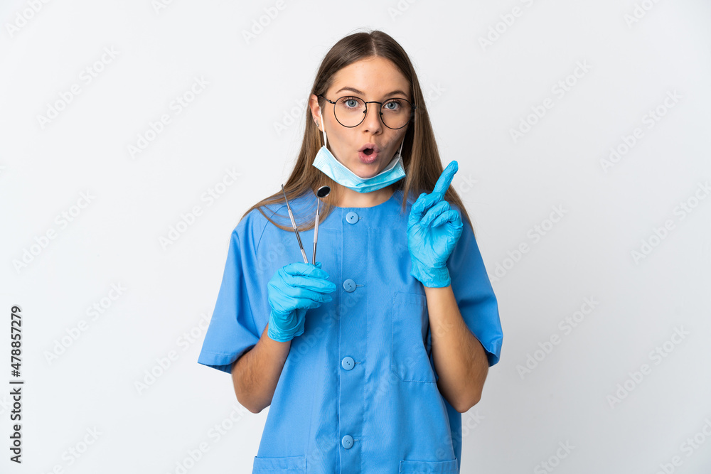 Lithuanian woman dentist holding tools over isolated background intending to realizes the solution while lifting a finger up Lithuanian woman dentist holding tools over isolated background intending to realizes the solution while lifting a finger up