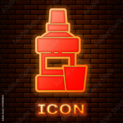 Glowing neon Mouthwash plastic bottle and glass icon isolated on brick wall background. Liquid for rinsing mouth. Oralcare equipment. Vector