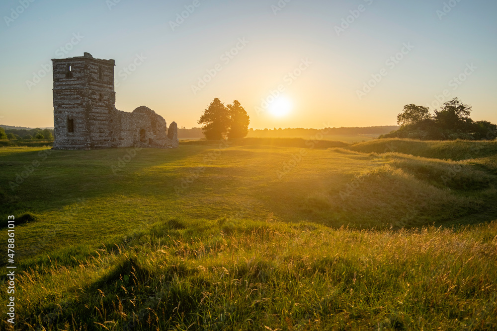 Sunrise over the old ruins of Knowlton Church And Earthworks with sun illuminating the surrounding landscape. Knowlton, Wimborne, Dorset, England